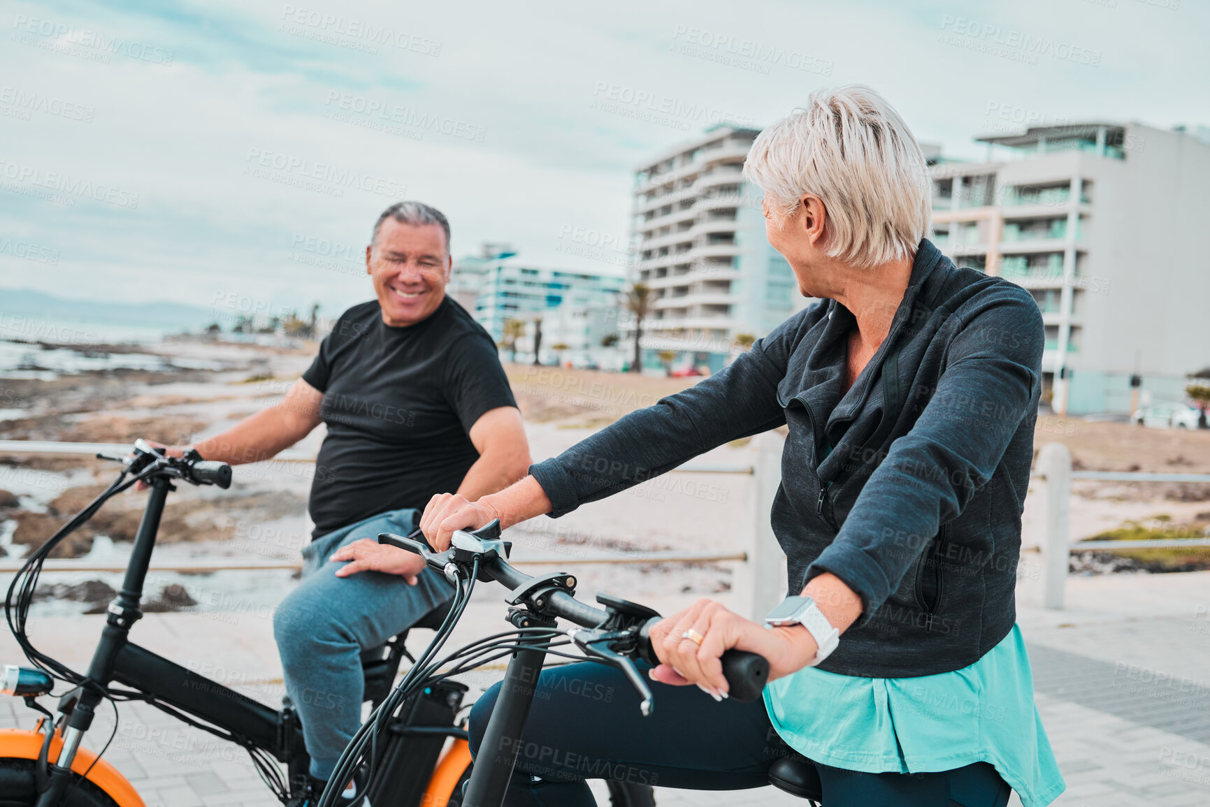 Buy stock photo Mature people, electrical or bike by ocean, beach or sea in bonding transportation, clean energy or sustainability travel. Ebike, electricity or eco friendly bicycle for happy couple or cycling woman