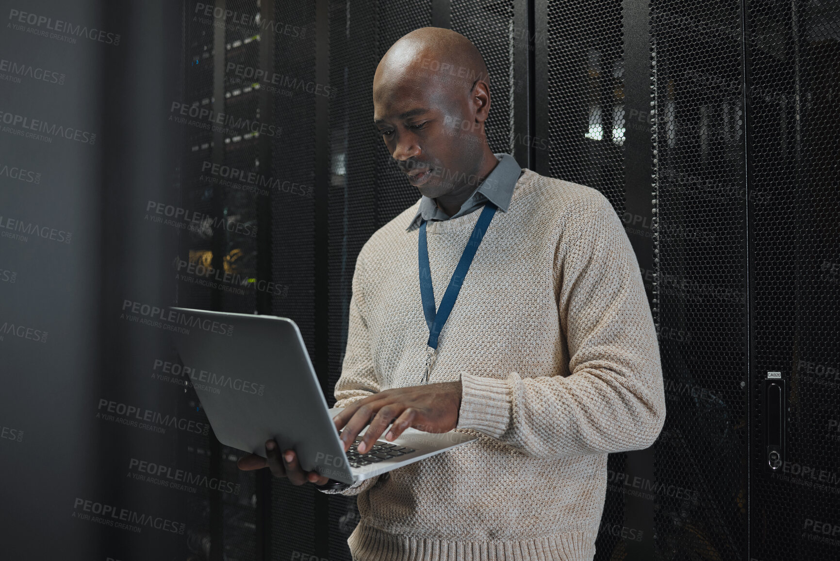 Buy stock photo Laptop, server room and black man or technician in data center management, system or cybersecurity. Analysis, serious or power coding solution, engineering programmer or information technology person
