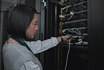 Asian woman, technician and server room for cabling, networking or system maintenance at office. Female engineer plugging wire for cable service, power or data security in admin or network management
