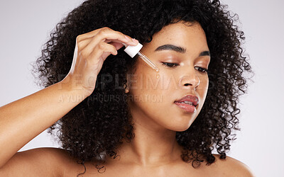 Buy stock photo Cosmetics, black woman and skincare with pipette, oil and girl with beauty against grey studio background. African American female, lady and liquid serum for dermatology, collagen and organic facial