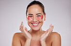 Asian woman, portrait smile and eye patches for skincare cosmetics, collagen or facial against a gray studio background. Happy female smiling in beauty with face mask or patch under eyes for wellness