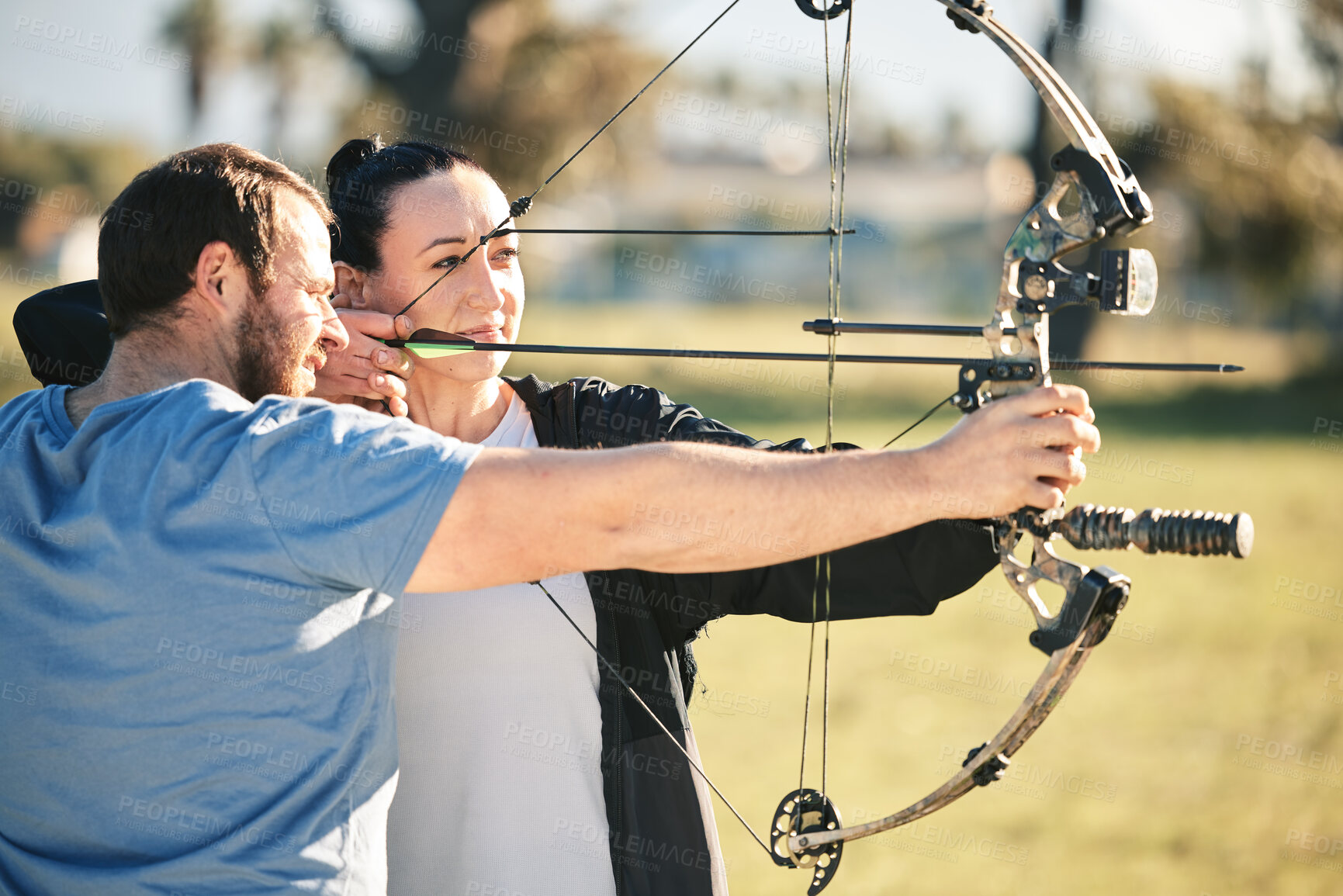 Buy stock photo Archery, aim and shooting range sports training with a woman and man outdoor for target practice. Archer and athlete person with focus on field for competition or game with bow and arrow for action