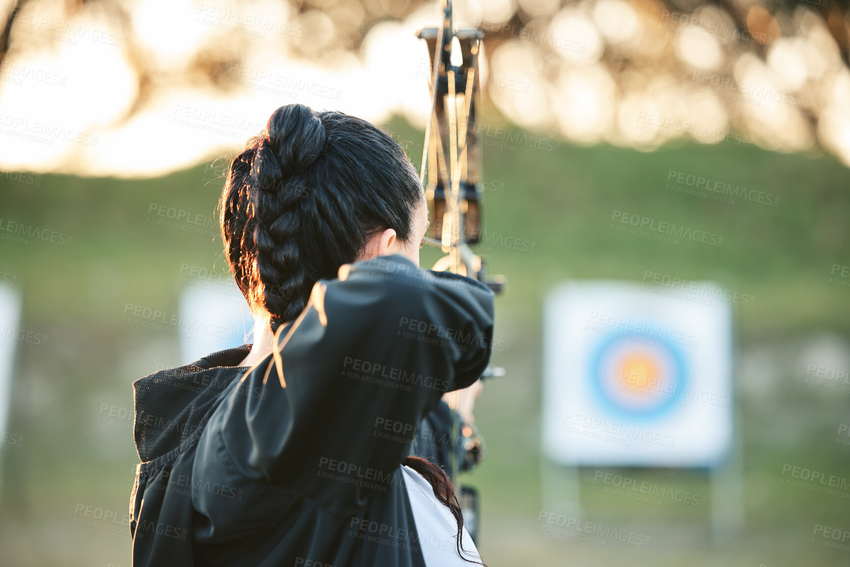 Buy stock photo Archer, arrow target training and practice for archery competition, athlete challenge or competitive shooting. Sports field girl, bow hunting and woman focus on precision, aim or back view objective