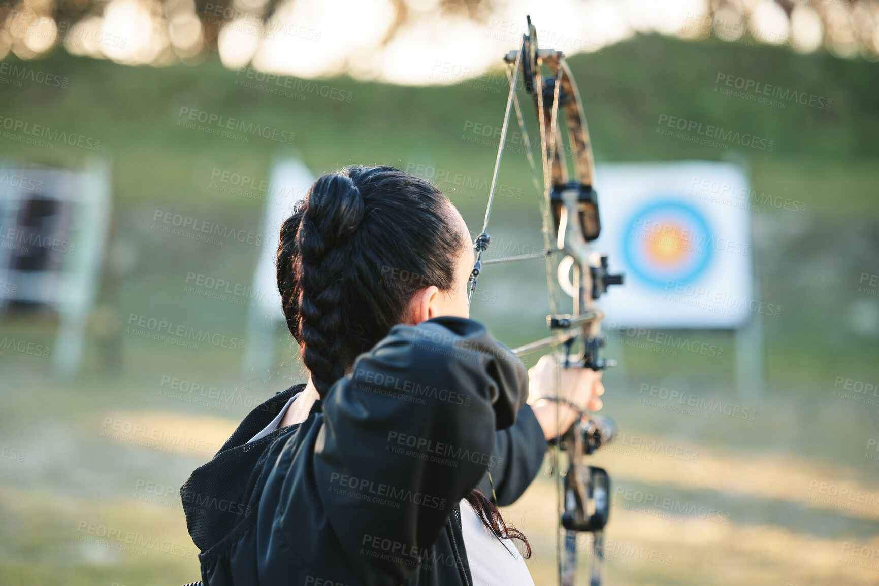 Buy stock photo Archery, shooting range and target for sports training with a woman outdoor for bow practice. Archer athlete person with focus on field for competition or game to aim arrow for action and bullseye