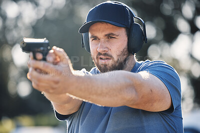 Buy stock photo Man, gun and learning to aim at shooting range outdoor for security target training. Face of person train with safety gear headphones for focus on sport competition with firearm weapon in hands