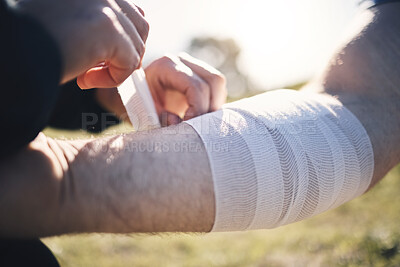Buy stock photo Hands, arm bandage and first aid after injury, workout or exercise accident outdoors. Medical emergency, help and injured male athlete man with plaster or strap after sports training or exercising.