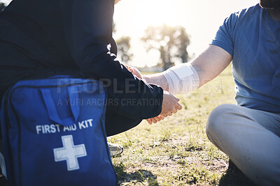 Buy stock photo First aid, help and arm injury by man with medic on the ground during morning cardio outdoors. Medical, emergency service and injured male with bandage on a field after exercise, workout or walk