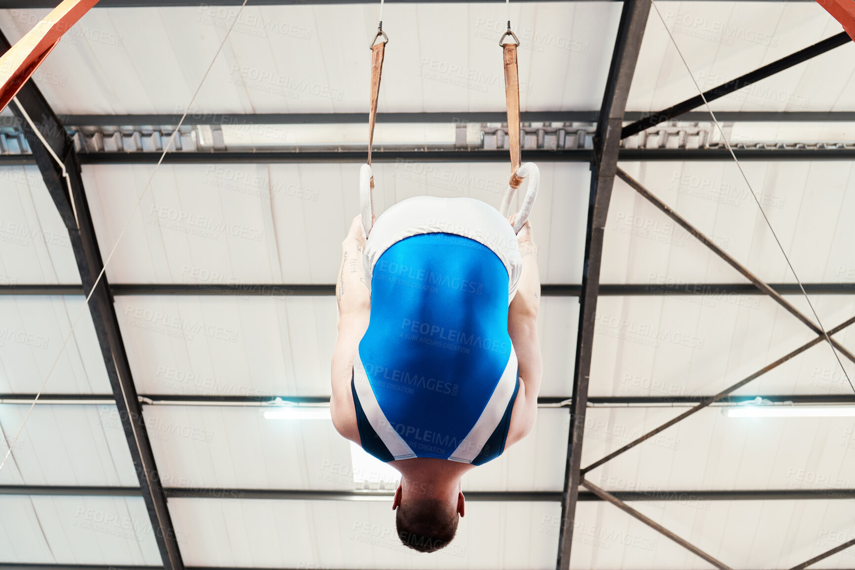 Buy stock photo Man, acrobat and gymnastics on rings in fitness for practice, training or workout performance at gym. Professional male gymnast hanging on ring circles for athletics, acrobatics or strength exercise