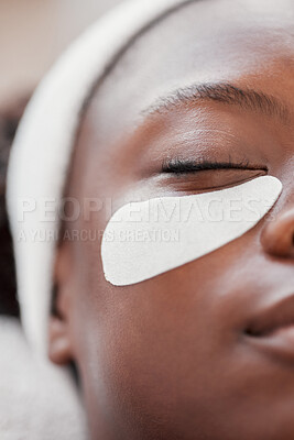 Buy stock photo Closeup, cosmetics and black woman, eye patch and skincare for beauty, wellness and luxury treatment. Zoom, Nigerian female client and lady applying skin mask, moisturize and organic facial for shine