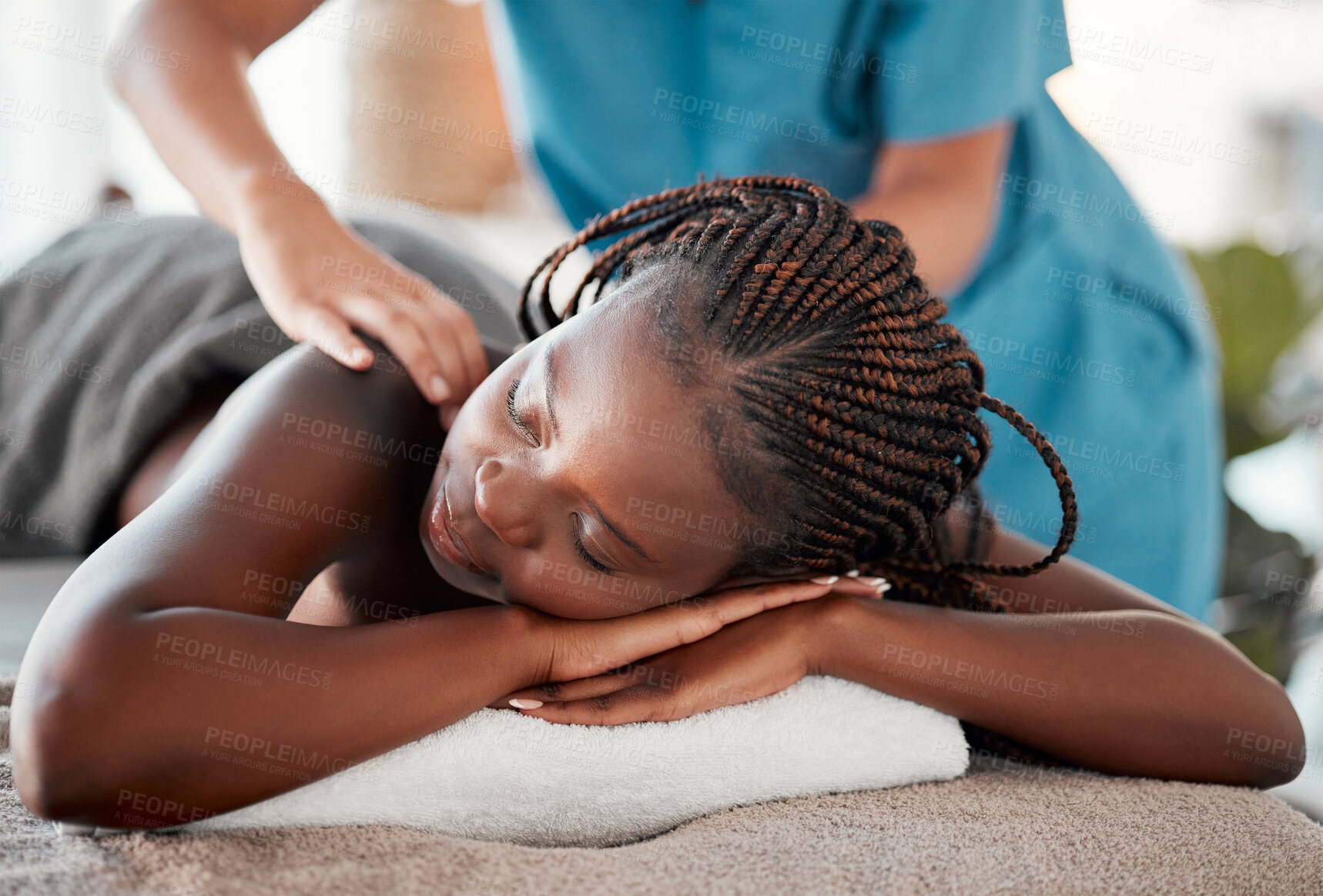 Buy stock photo Black woman, bed and relax in spa for back massage, deep tissue or relaxation in stress relief at resort. Happy African American female relaxing with hands of masseuse massaging for physical therapy