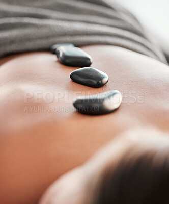 Buy stock photo Woman, rocks and back in spa relaxation for treatment, stress relief or massage at resort. Female relaxing with hot stone in physical therapy for skincare, body healing or zen wellness at salon