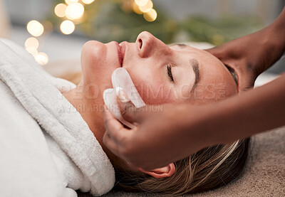 Buy stock photo Beauty, gua sha and woman getting a facial massage for wellness, health and self care at a spa. Skincare, cosmetic and calm young female doing a luxury face treatment with rose quartz at a zen salon.