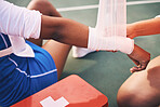 Sport injury, bandage and first aid with wrist pain and help, health and medic, accident and people on netball court. Medical emergency, train and sports, fitness and arm, anatomy and muscle sprain