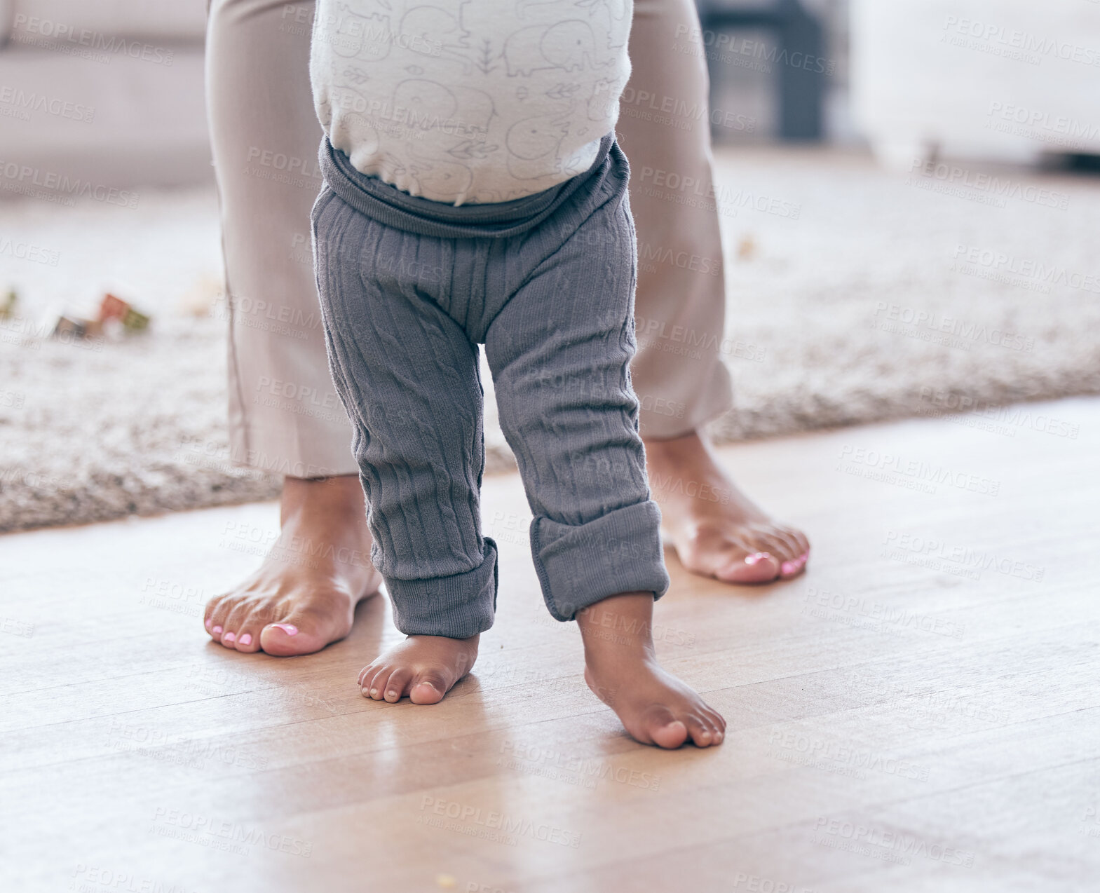 Buy stock photo Baby feet, walking and learning with mother in a living room lounge with mobility development. Floor, home and first steps of a young kid with mama together with love, care and support in a house