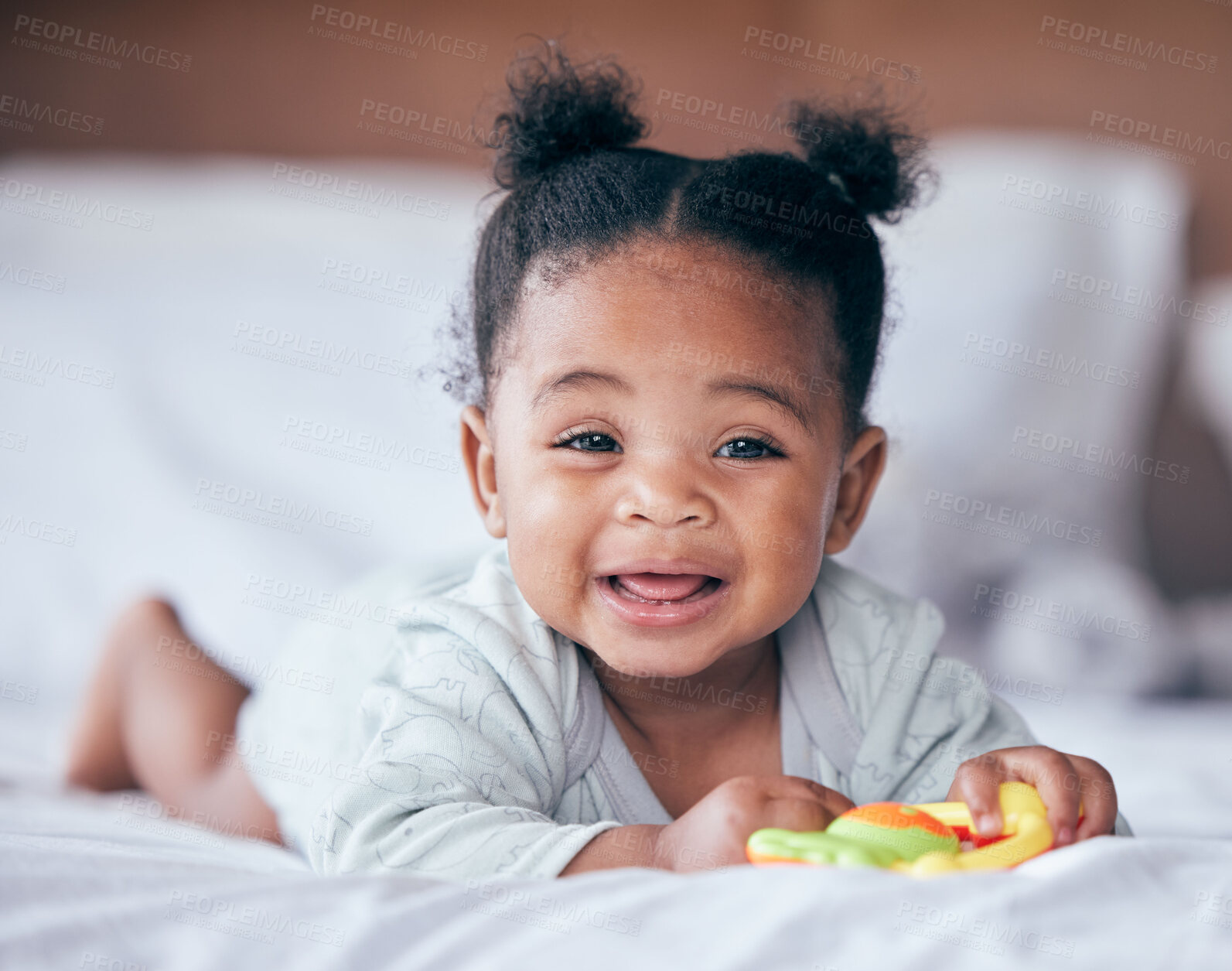 Buy stock photo Happy, smile and portrait of a baby on a bed playing with a toy while relaxing in her nursery. Happiness, excited and girl infant or newborn laying in her bedroom while being playful in her house.