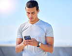 Phone, fitness and man texting on social media or streaming music online during morning exercise or workout routine. Person, web and athlete using a mobile training app or website to track health