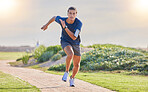 Fitness, runner in park and man running for cardio, action and energy outdoor, health and wellness in active lifestyle. Exercise, training for race or marathon, healthy and freedom with run in nature