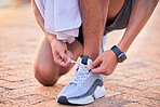 Closeup, outdoor and man with fitness, shoelace and runner with wellness, training and healthy lifestyle. Zoom, male athlete and guy with smartwatch, tying shoes and exercise for workout or endurance