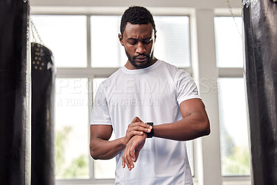 Buy stock photo Fitness, gym and black man with smart watch for time, health app or tracking wellness goals. Sports, training and serious male athlete using technology for monitoring workout or exercise targets.