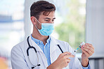 Man, doctor and hands with face mask, vaccine or syringe for cure, illness or medication at the hospital. Male medical professional extracting medicine from vial for covid immunization or disease