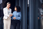 Tablet, collaboration and a business woman team at the office for planning or strategy together by a window. Meeting, teamwork or research with a female employee and colleague talking outside