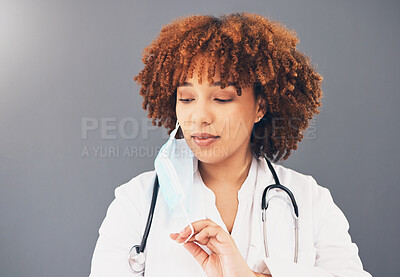 Buy stock photo Black woman, doctor and covid 19, remove face mask and health, end of pandemic and protection on studio background. Serious, mockup space with healthcare, safety and post coronavirus with female