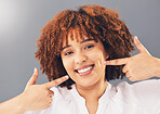 Portrait, teeth and black woman pointing, excited and dental hygiene against grey studio background. Face, Jamaican female and girl with smile, oral health and gesture to dimples, mouth and wellness