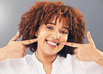 Portrait, point and teeth with black woman, smile or oral hygiene against grey studio background. Face, African American female or lady with gesture for mouth, happiness or dental health for wellness
