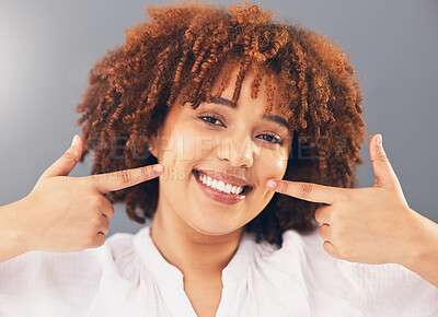 Buy stock photo Portrait, point and teeth with black woman, smile or oral hygiene against grey studio background. Face, African American female or lady with gesture for mouth, happiness or dental health for wellness