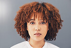 Beauty, afro and black woman face or activist for empowerment and looking serious, confident and proud. Portrait, head and African American female with curly hair isolated in gray background