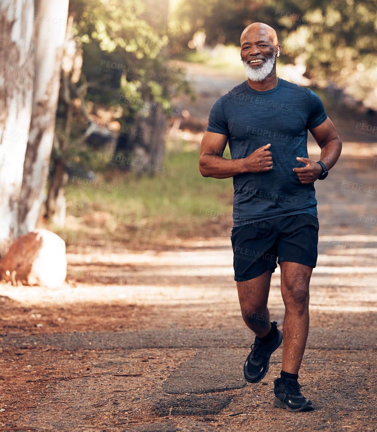 Buy stock photo Music earphones, running and black man in nature for health, wellness and fitness. Radio, podcast and smile of happy senior athlete training, exercise and workout, cardio and jog outdoors at park.