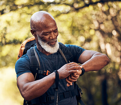 Buy stock photo Fitness, mature and black man reading time while walking, running or trekking in nature. Exercise, training and senior African person with watch for physical activity progress and heart rate monitor
