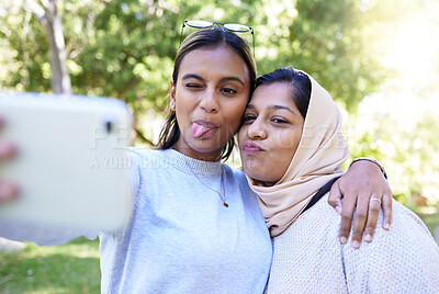 Buy stock photo Girl, friends and muslim for funny face selfie with smile, hug or happy for summer, adventure or outdoor bonding. Women, hijab and profile picture on social media app, happiness or together in nature