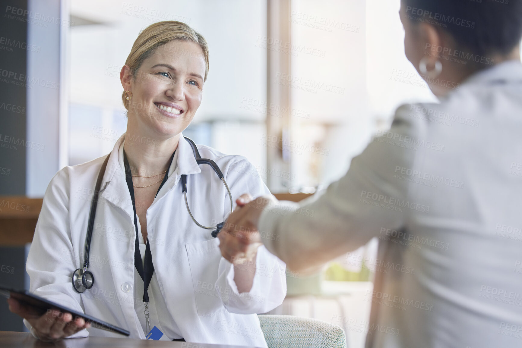 Buy stock photo Handshake, healthcare or trust with a doctor woman and patient in a hospital for a checkup or diagnosis. Medical, wellness and insurance with a medicine professional shaking hands to say thank you