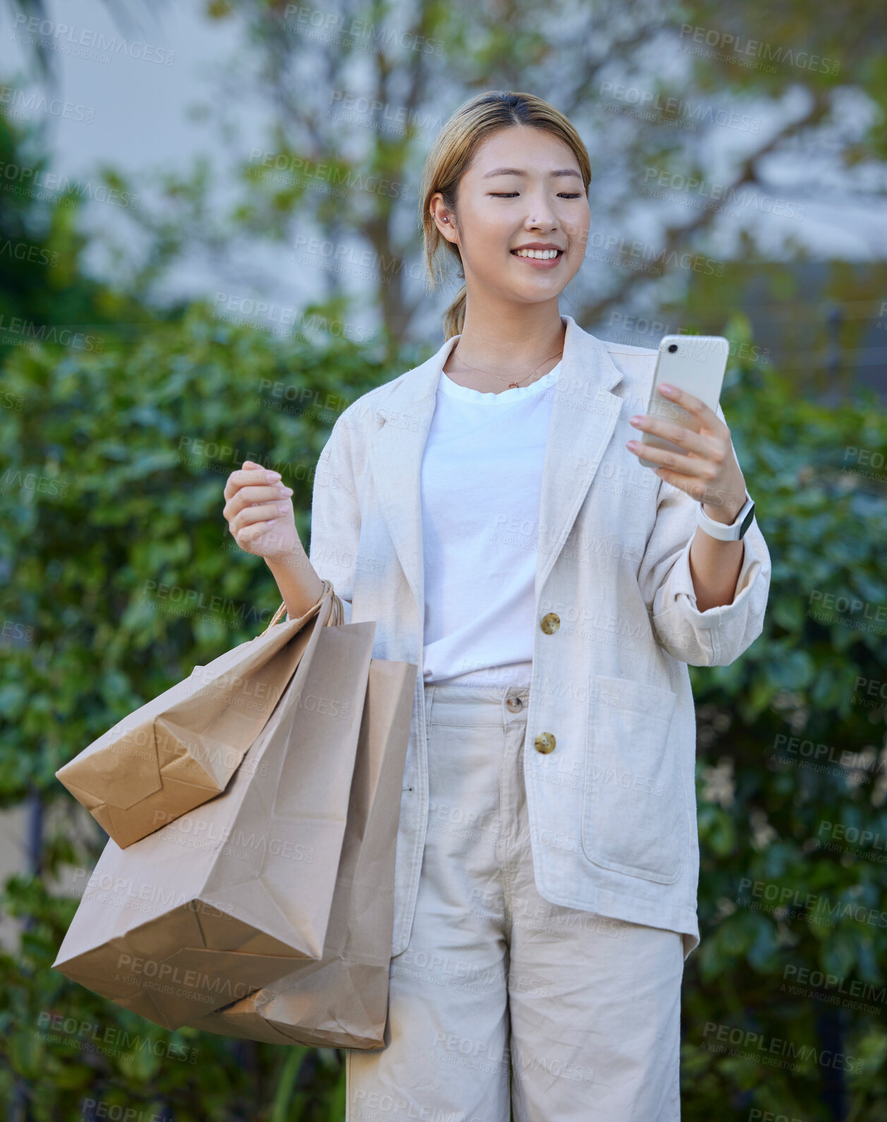 Buy stock photo Bags, shopping and Asian woman typing with phone outdoors after buying at mall. Technology, 5g cellphone and smile of happy female with mobile smartphone for social media, sales deals or discount.