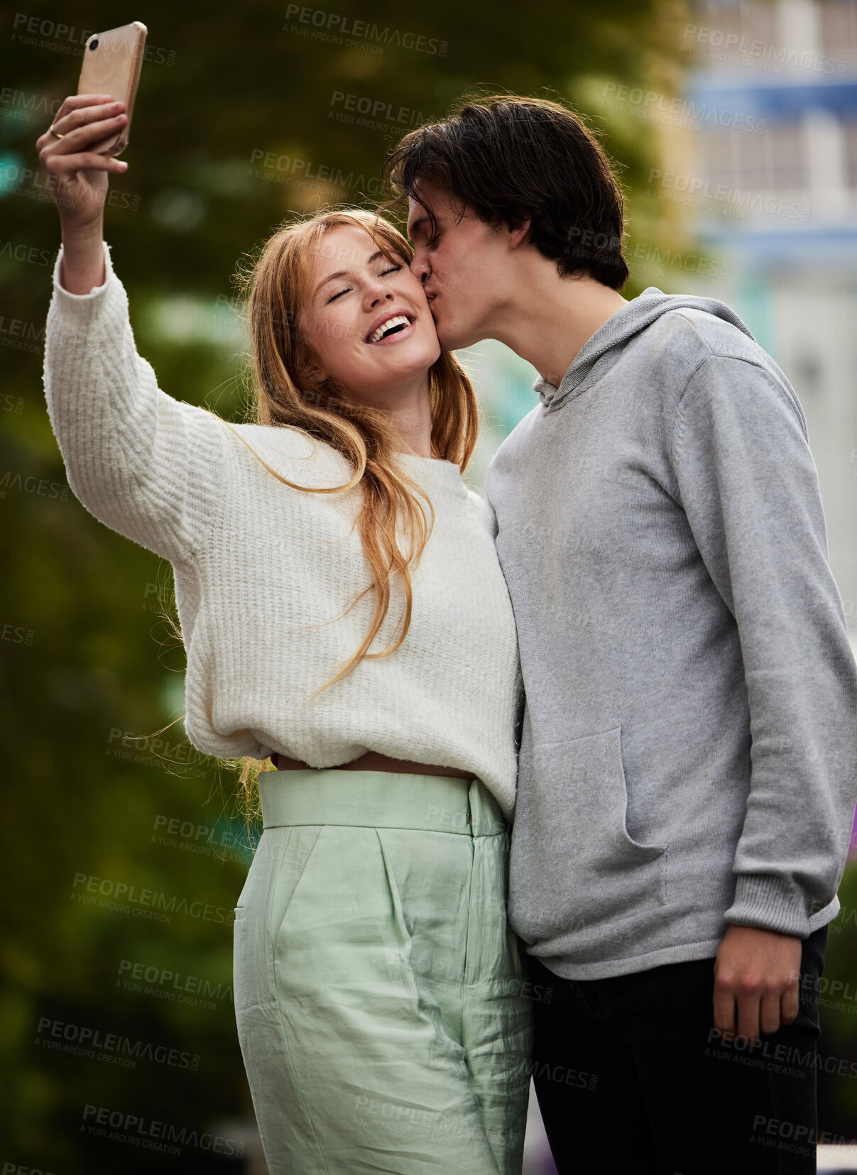 Buy stock photo Couple take selfie, man kiss woman with happiness outdoor, social media content and memory with love and relationship. Commitment, partnership and trust with travel, smile in picture and gen z people