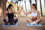 Yoga, outdoor and women high five for exercise in nature for fitness, goals and wellness. Friends or people on forest ground to celebrate with hands for workout achievement, mental health and zen