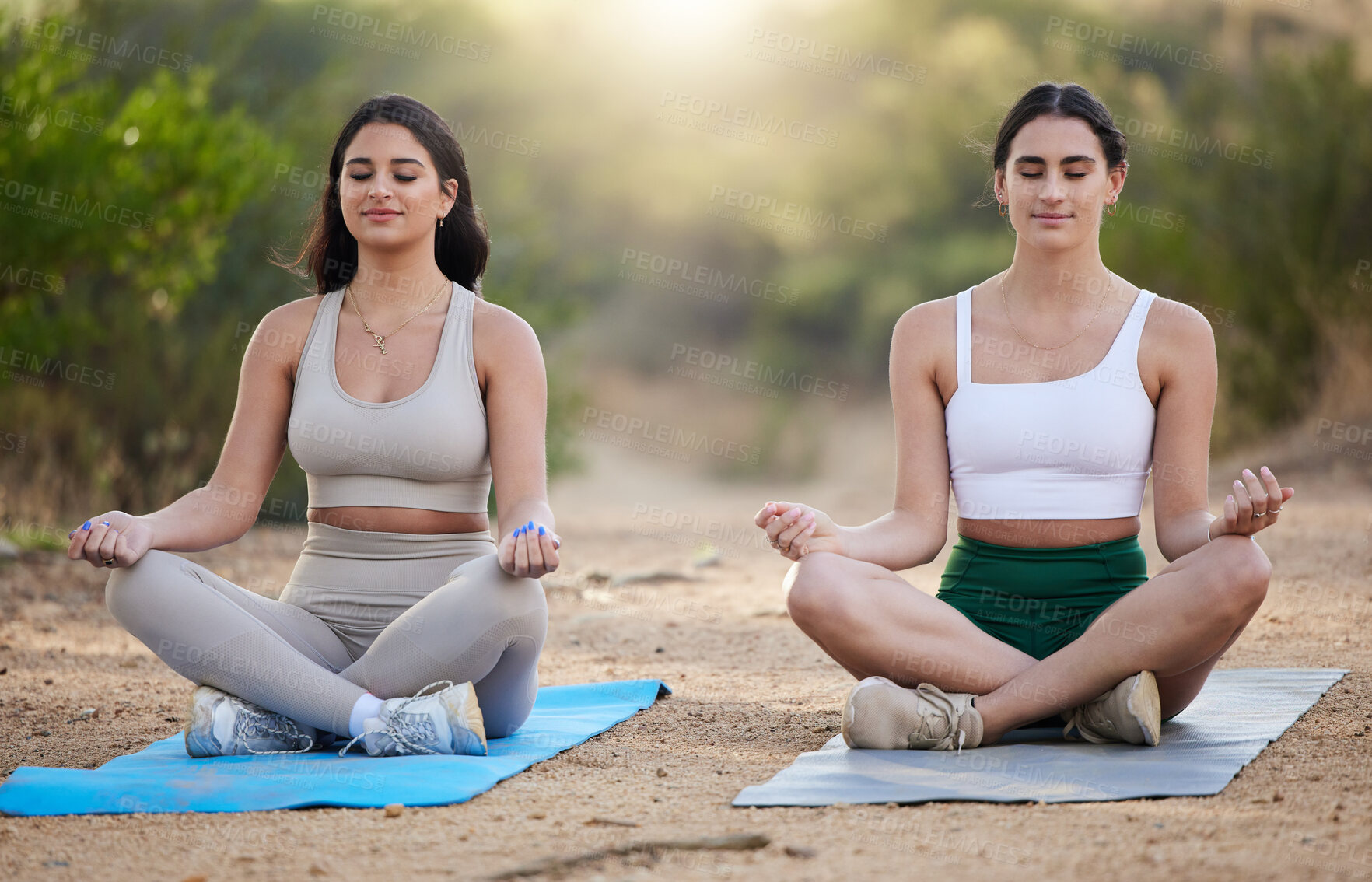 Buy stock photo Yoga, meditation and peace with woman friends outdoor in nature, sitting on a mat for mental health or wellness. Fitness, forest or mindfulness with a young female yogi and friend meditating outside