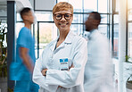 Portrait, medical and motion blur with a doctor black woman standing arms crossed in a busy hospital. Healthcare, insurance and trust with a female medicine professional in a clinic for treatment