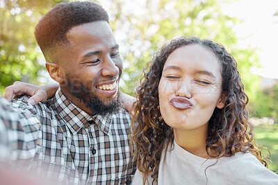 Buy stock photo Couple of friends in selfie at park for summer holiday, happy date and funny face for social media. Diversity or interracial gen z or young people in nature with profile picture update and emoji kiss