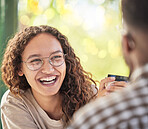 Face, happy or date and a black woman drinking coffee in the park with her boyfriend during summer. Smile, love and dating with a young female smiling at her partner for romance or affection