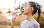 Fitness, health and woman drinking water in nature after exercise, training or workout. Sports, nutrition bottle and female athlete drink liquid for hydration after exercising, jog or cardio outdoors