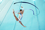 Gymnast, woman with ribbon for dance and performance, flexibility with professional athlete in gym and top view. Rhythmic gymnastics, leg in air with fitness, grace and action, dancing and stretching