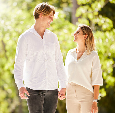 Buy stock photo Couple, walking and smile in park, garden and nature for partner love, romantic care or happiness together. Happy man, young woman and walk outdoor in sunshine, summer date or relax on valentines day