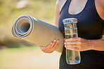 Closeup, hands and yoga by woman with water, mat and wellness, exercise and zen in nature. Zoom, pilates and hand of girl in countryside for mental health, zen and cardio, meditation and workout