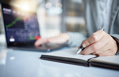 Trader, hands and writing notes in book by laptop on stock market chart or  graph statistics for trading at the office. Hand of investor or broker  taking note of bitcoin, cryptocurrency or