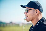 Coach, blowing whistle and sports training on a field with a man outdoor for competition or challenge. Fitness trainer or teacher person face profile for athlete game, coaching and pitch strategy