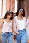 Shopping, city and happy friends or women walking together for retail discount, sale and promotion with gen z lifestyle. Young diversity people walk in urban street for fashion, wealth and clothes