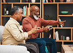 Gaming, pointing and senior black man friends playing a video game together in the living room of a home. Sofa, funny or retirement with a mature male gamer and friend enjoying a house visit to game
