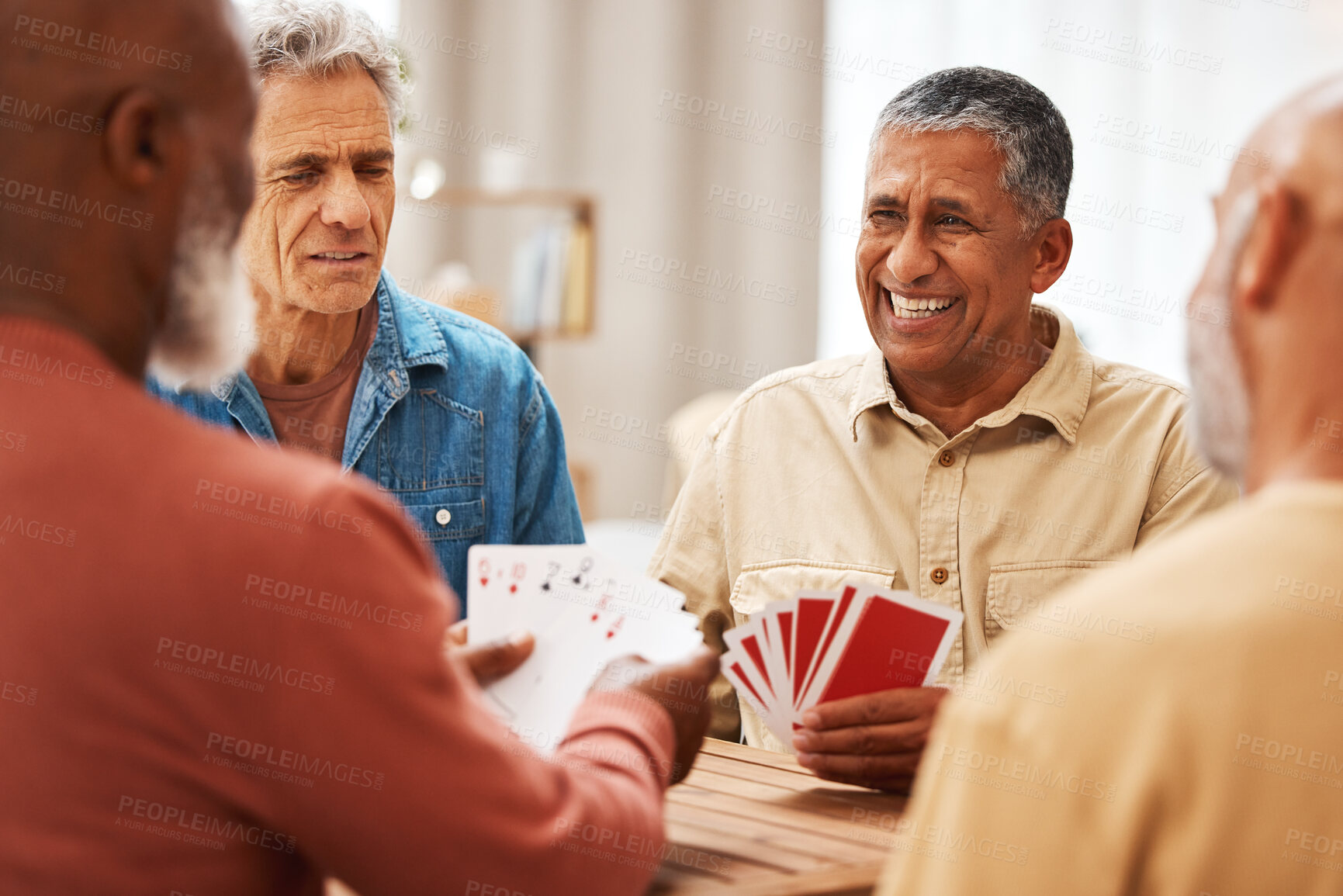 Buy stock photo Senior man, friends and playing card games on wooden table in fun activity, social bonding or gathering. Group of elderly men having fun with cards for poker game enjoying play time together at home